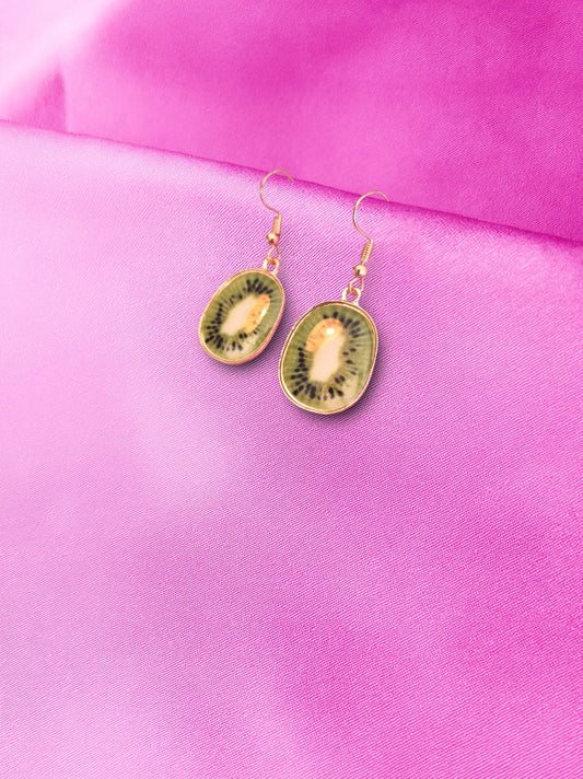 Kiwi fruit-shaped earrings on a pink fabric background
