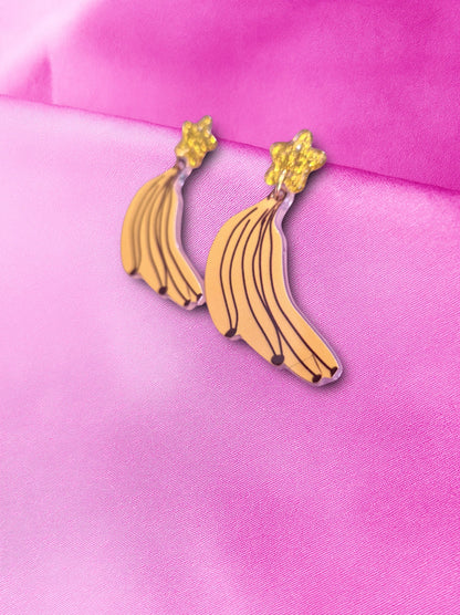 Banana-shaped earrings on a pink background