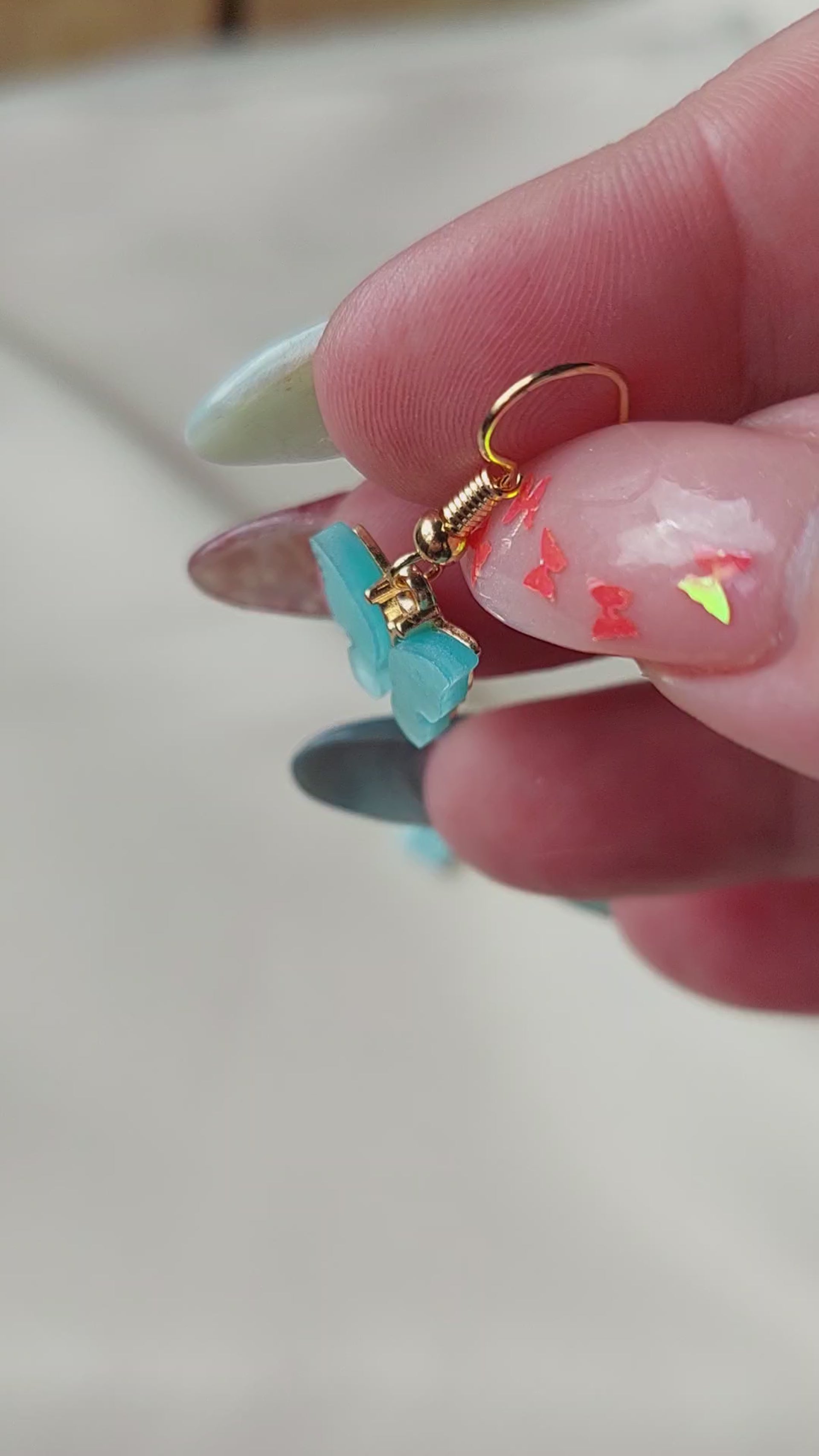 Blue butterfly earrings with gold body. Gold hooks. Hand shown to scale. 