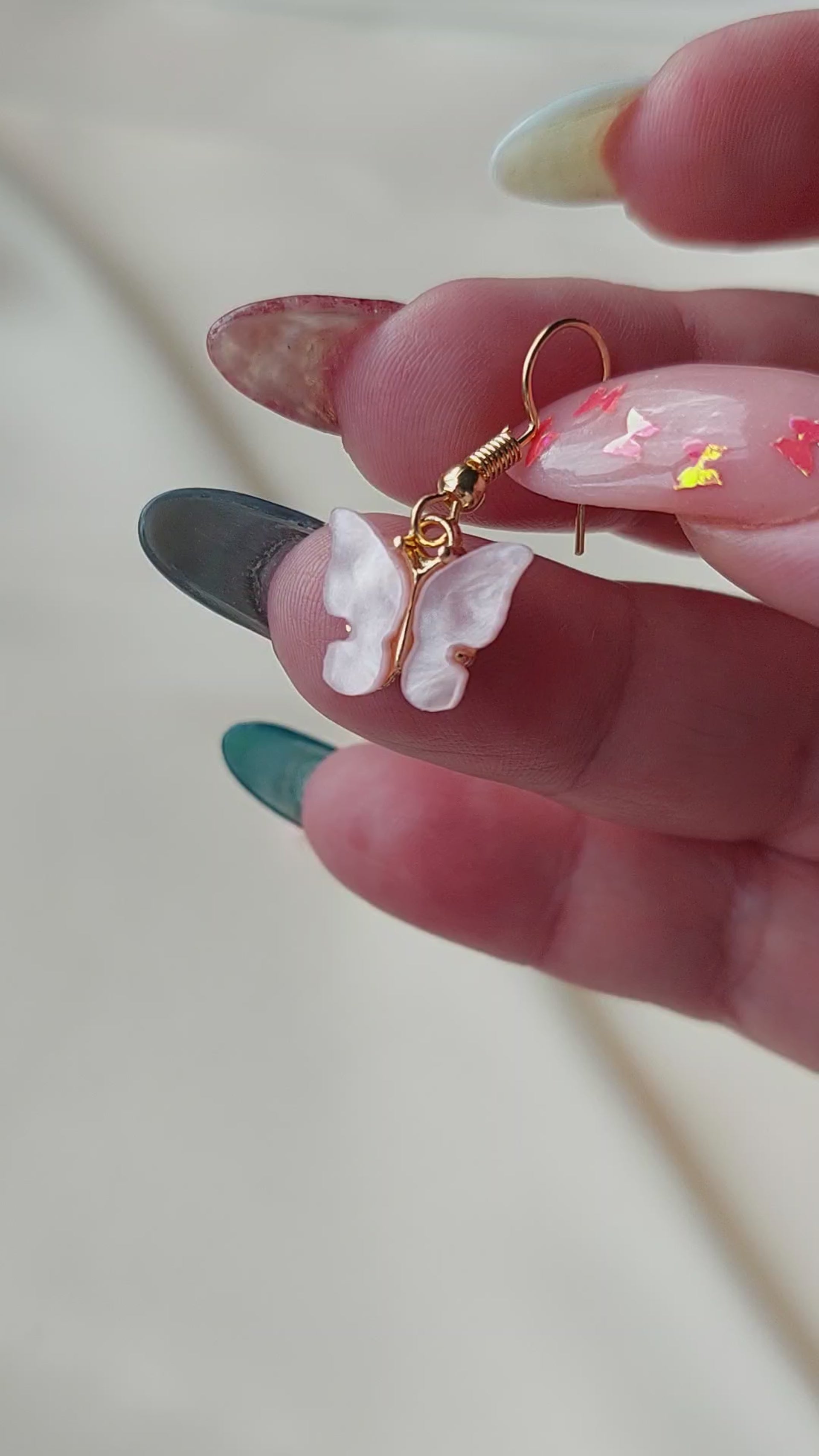 Pink butterfly earrings with gold body. Gold hooks. Hand shown to scale. 